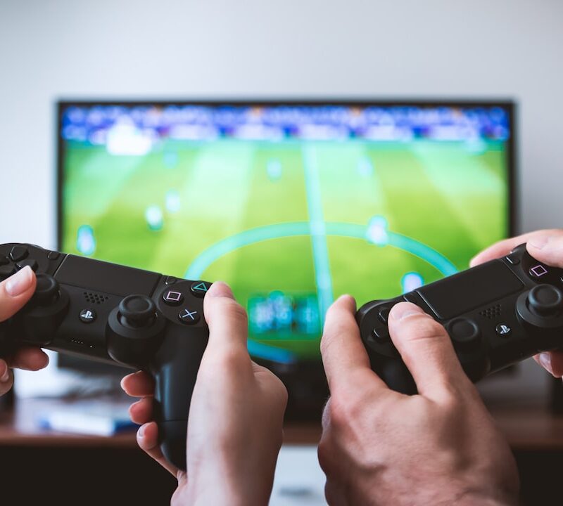 Controle de videogame prateado caindo no chão com movimento borrado, fundo neutro.