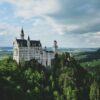 Castelo medieval em paisagem sombria e atmosférica, evocando cenário de fantasia épica