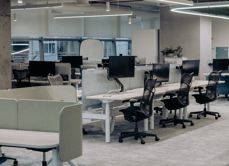 Escritório corporativo vazio com estações de trabalho, representando reestruturação empresarial